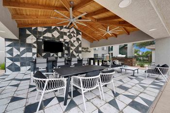 Outdoor kitchen area with large screen tv and fire pit